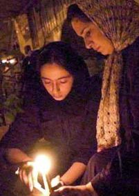 مادر و دختر ایرانی در تهران که در حال روشن کردن شمع به یاد کشته‌شدگان حملات ۱۱ سپتامبر هستند.