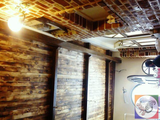 سقف چوبی با تیر چوبی و نورپردازی در دکوراسیون سنتی رستوران ایتالیایی