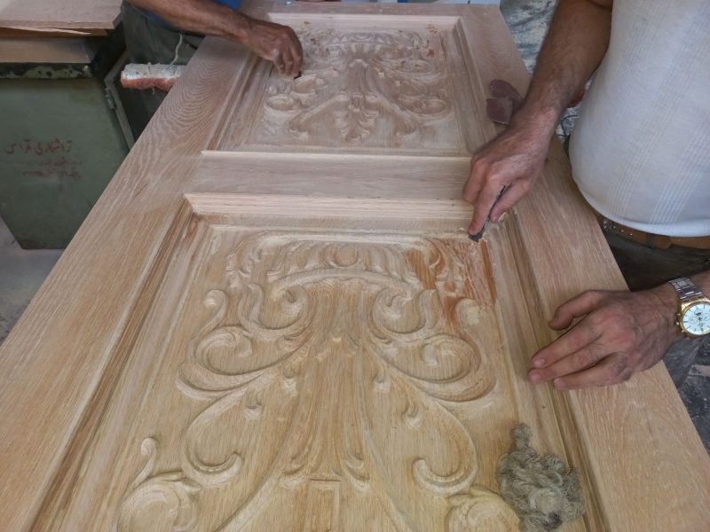 درب چوبی منبت کاری شده طرح گل و گلدان ، در مرحله رنگ